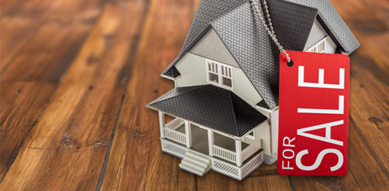 Small toy house on a wooden background symbolizing real estate closings.